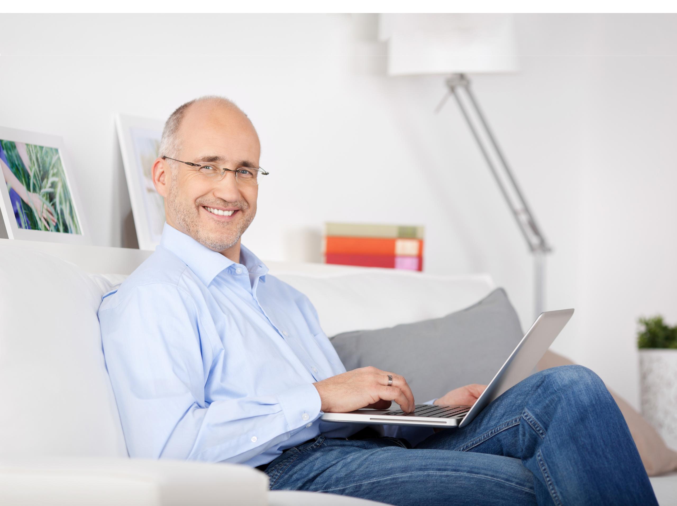 A man adjusting his thermostat and smiling because of the energy he is now saving