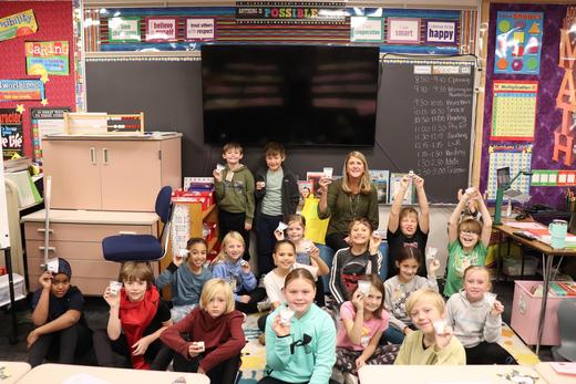 A classroom of students from Basswood Elementary School in Maple Grove hold up their new USB plugs.