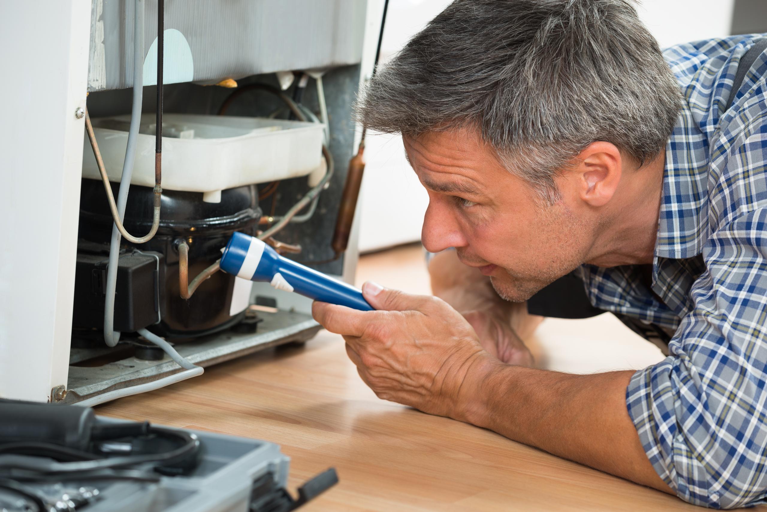 Wright-Hennepin Electric employee works on appliance repairs