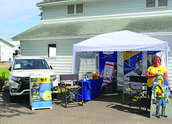 Wright-Hennepn employees pose by the WH booth at the Wright County Fair