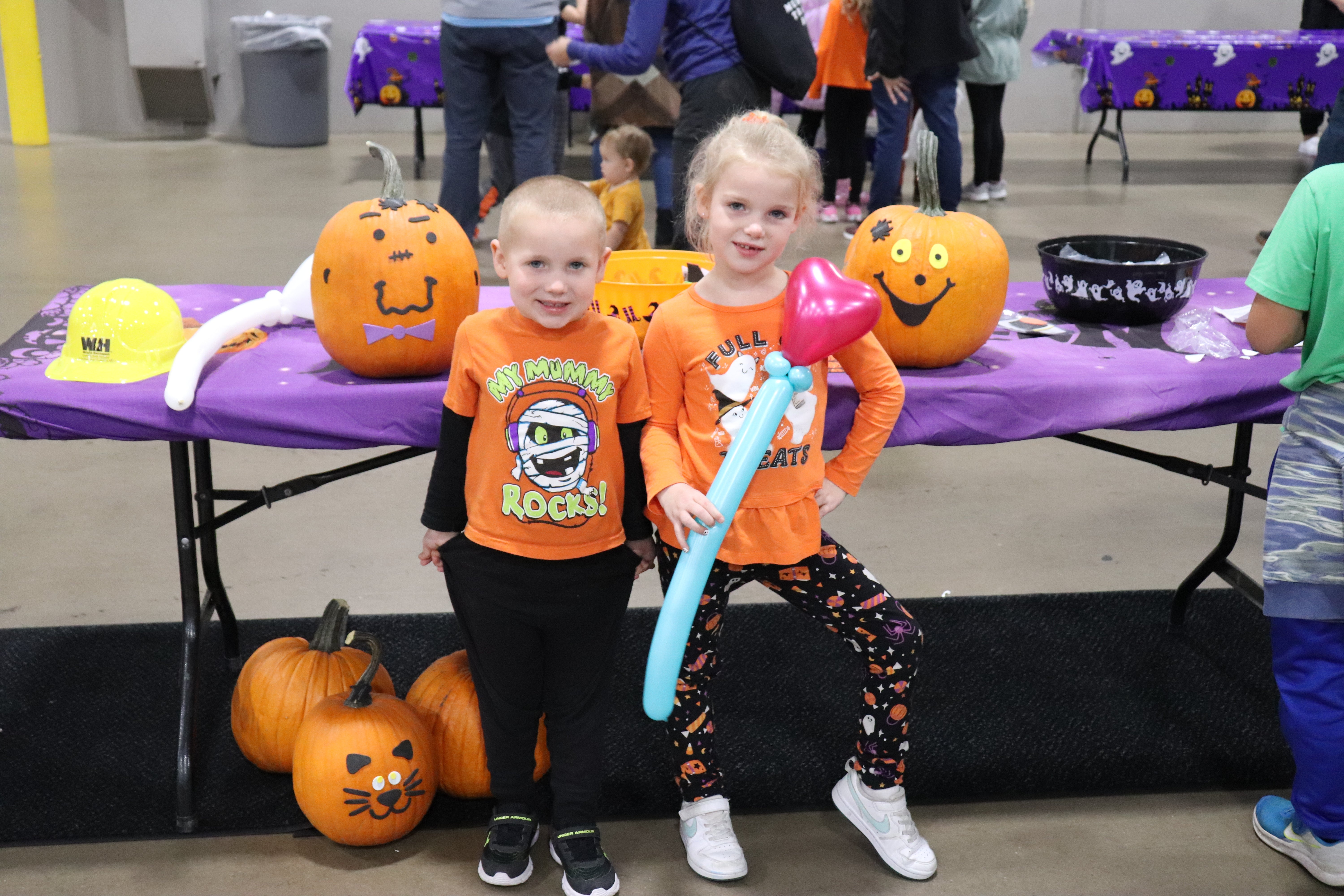 Two young girls with balloons with pumpkins at member event.