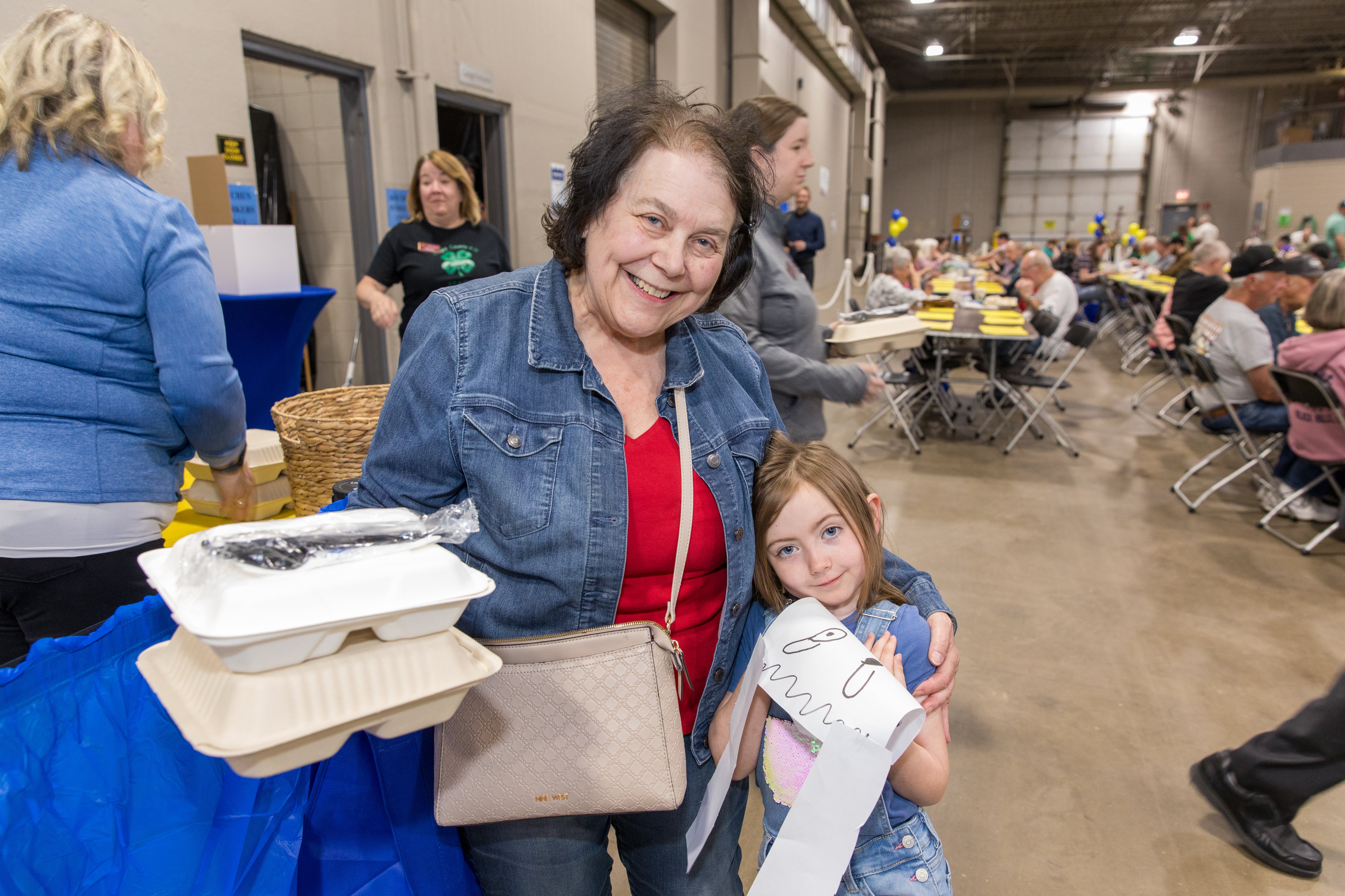 A family smiles with their box of pork chops