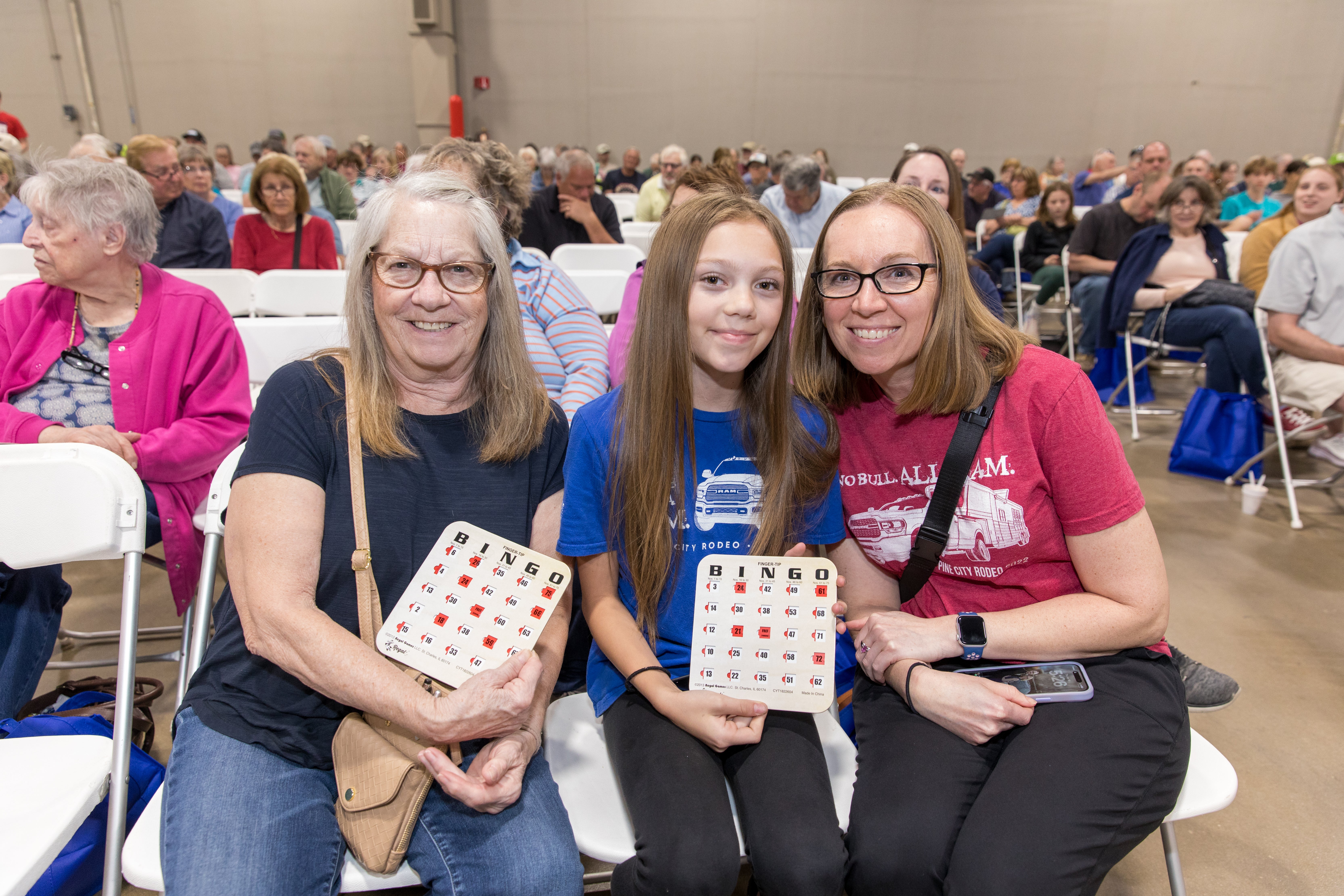 A family smiles with their bingo cards