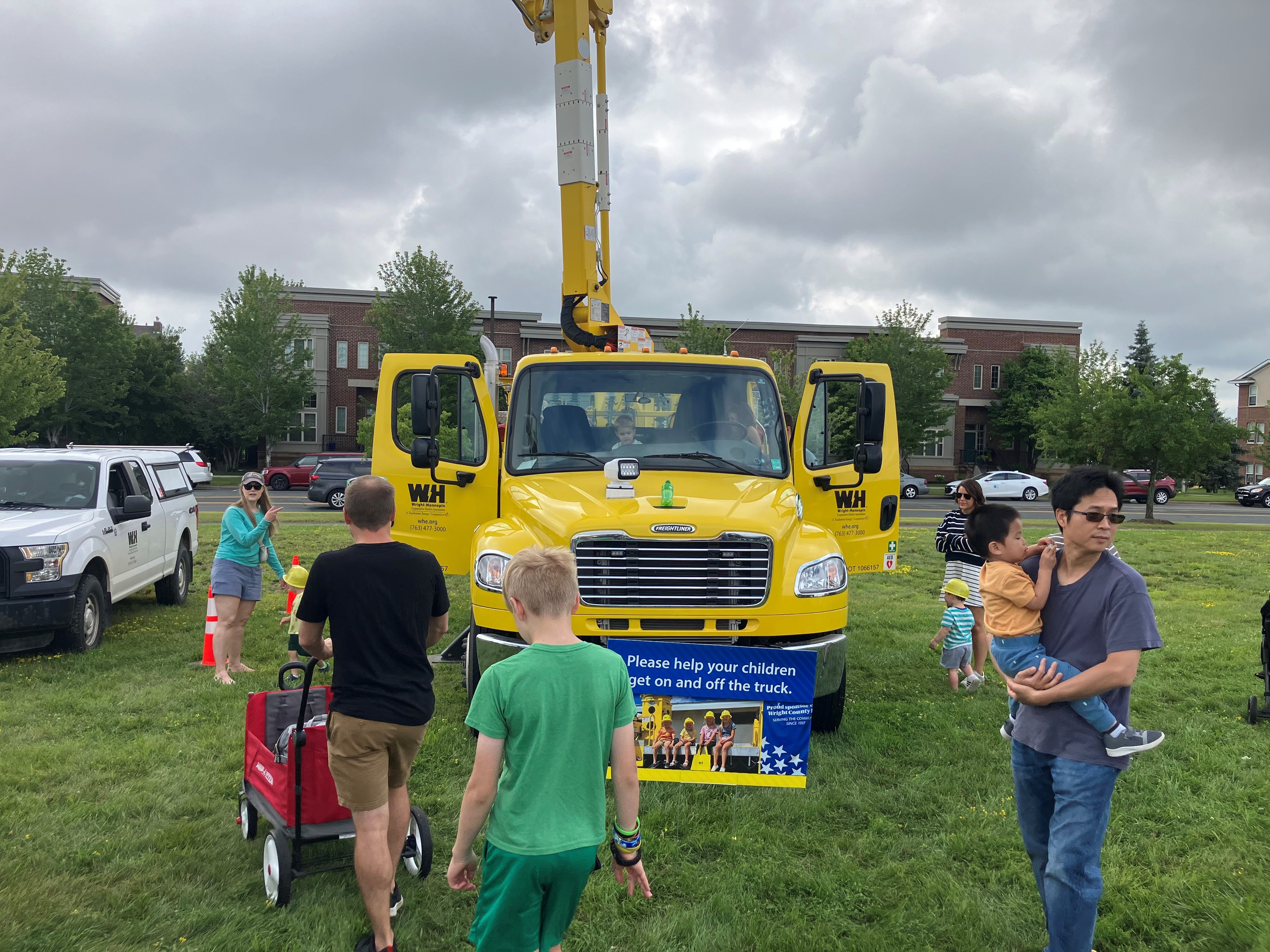 kids check out a yellow WH line truck