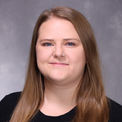 A white woman with brown hair looks at the camera