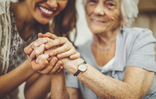 Mother and daughter hold hands reassuringly. 